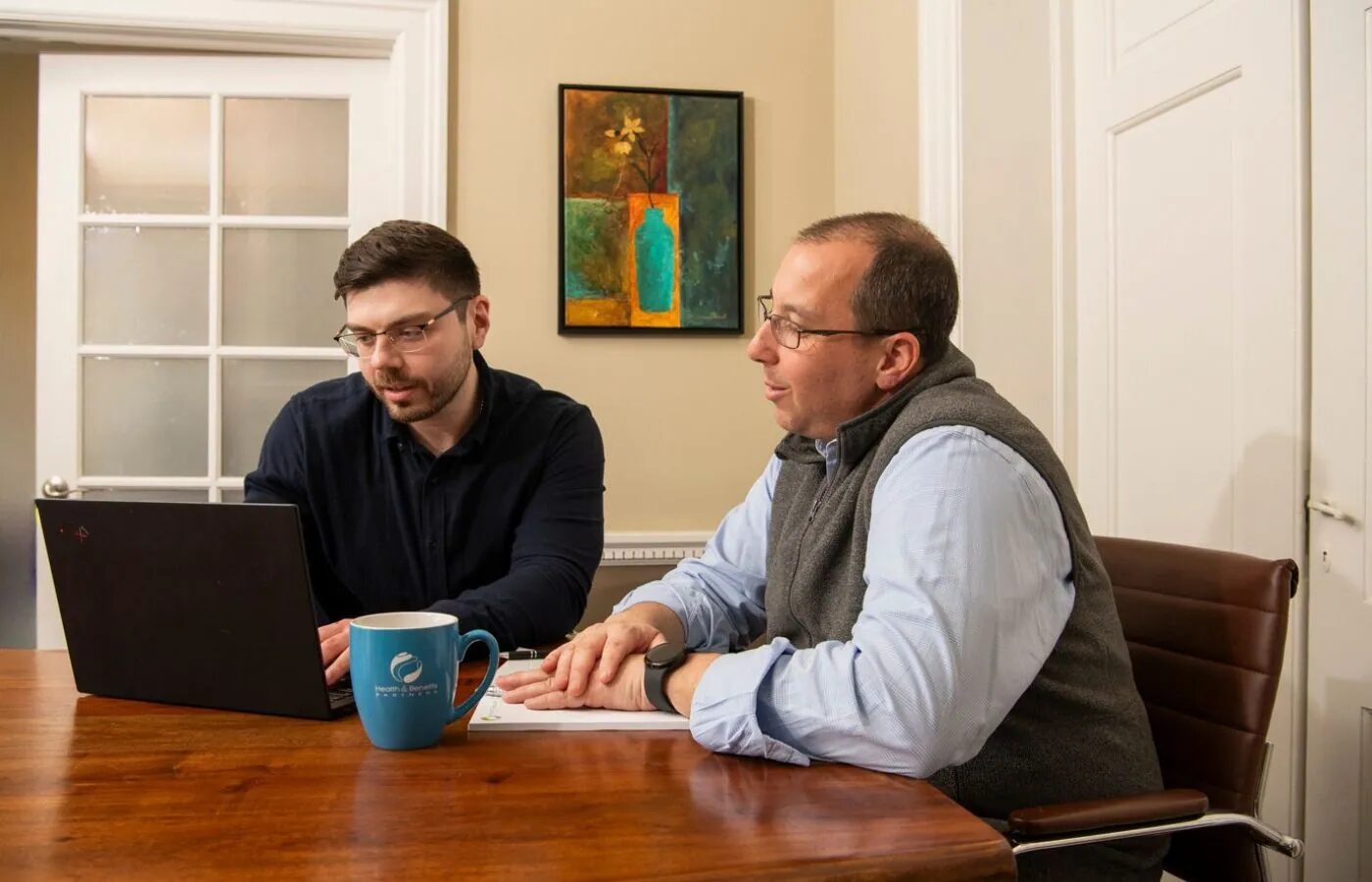 Team member reviewing insurance documents with a client in a meeting